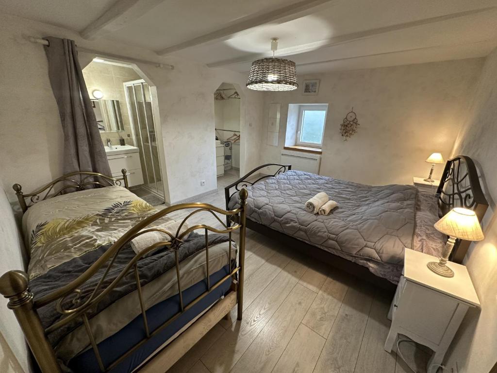 内顿斯La Ferme aux Diligences的一间卧室设有两张床和一张桌子上的台灯。