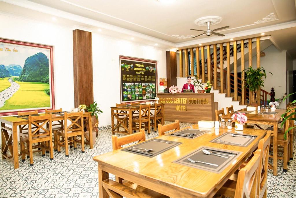 宁平Tam Coc Center Boutique Hotel的用餐室配有木桌和木椅