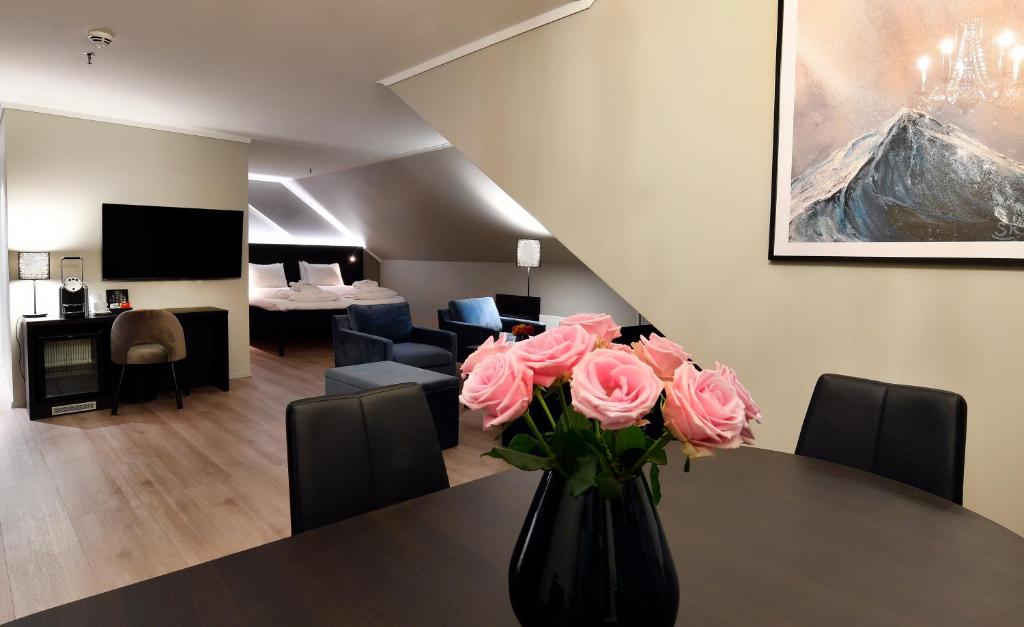 奥勒松Thon Partner Hotel Baronen的一张桌子上装满粉红色玫瑰的花瓶