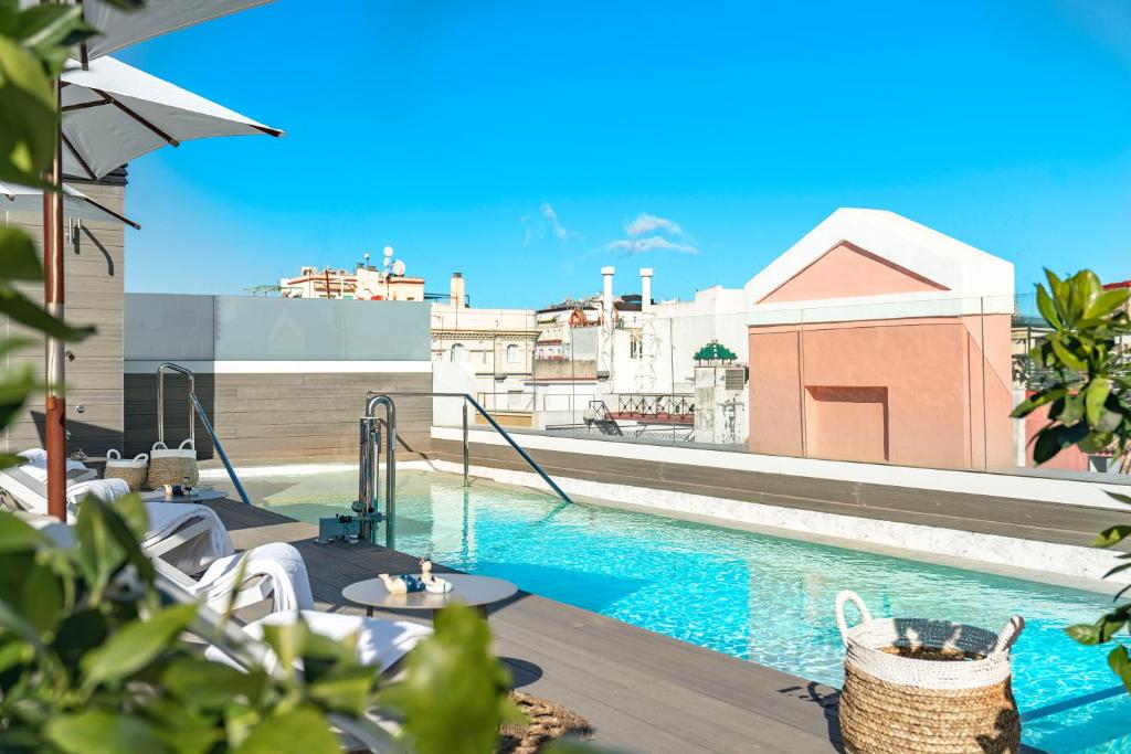 塞维利亚Vincci Molviedro Suites Apartments的享有大楼景致的游泳池
