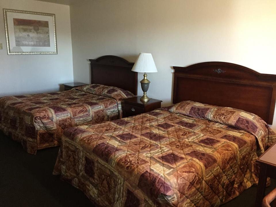 新港夏季风经济汽车旅馆的酒店客房,设有两张床和一盏灯