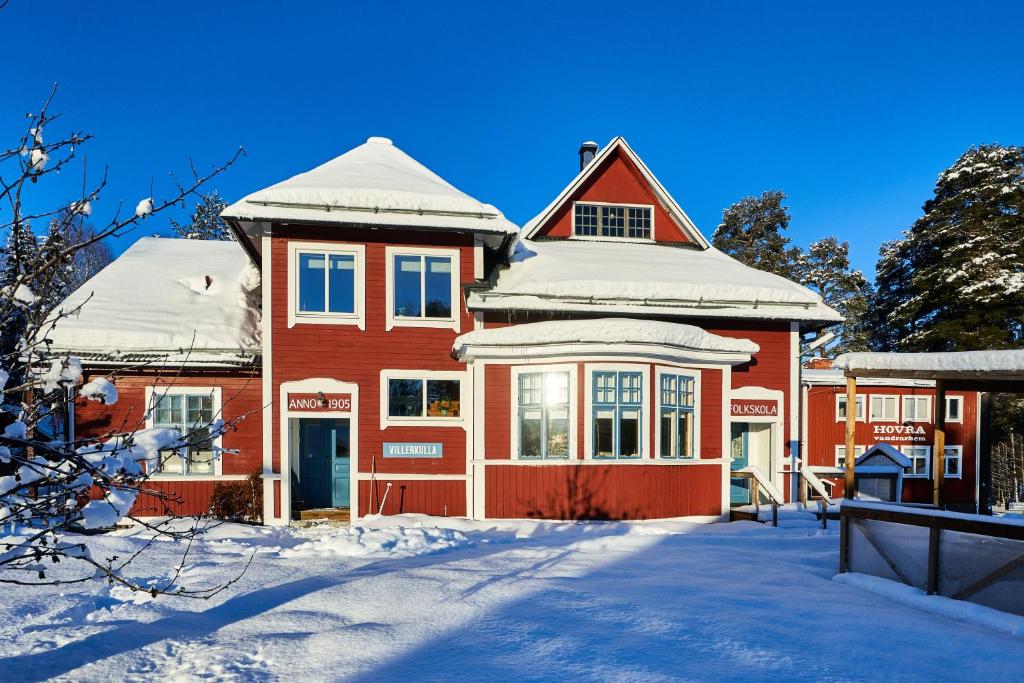 KorskrogenHovra Vandrarhem的一座红房子,上面有雪