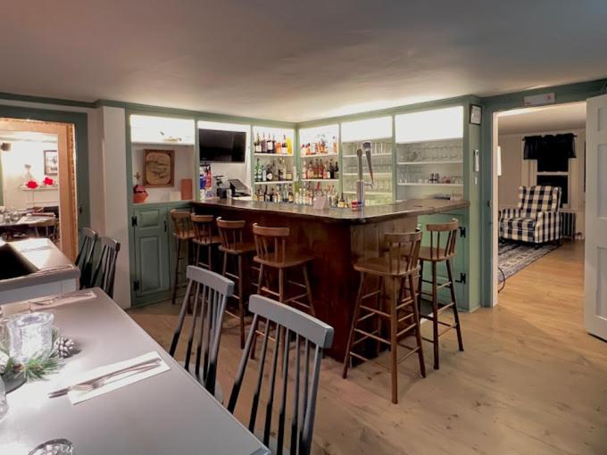 FrancestownBlue Bear inn的厨房设有带酒吧凳子的酒吧