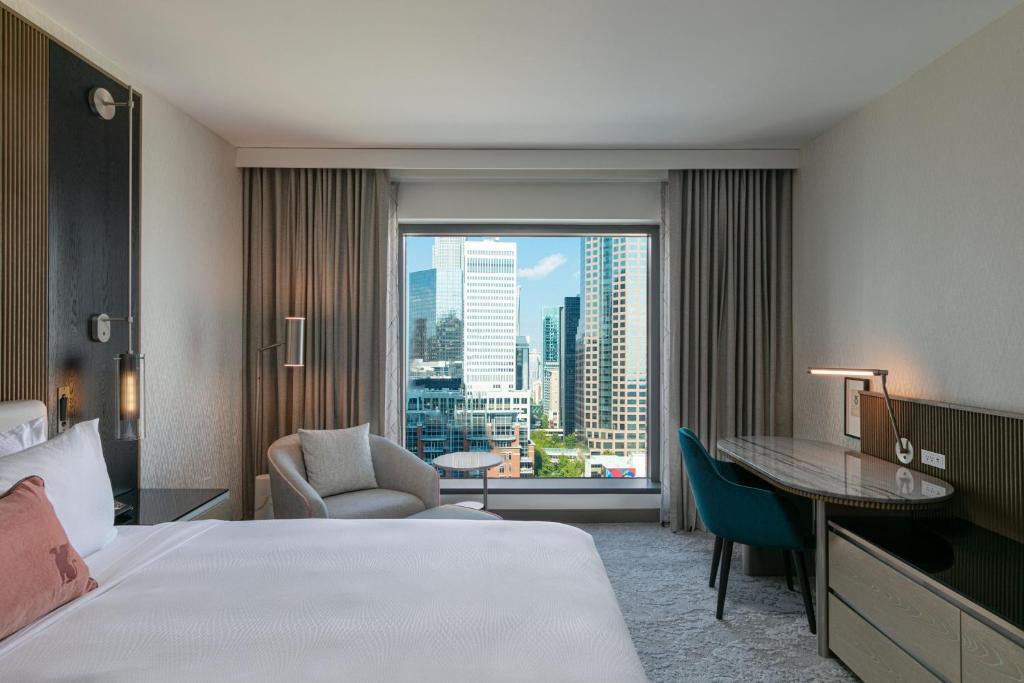夏洛特JW Marriott Charlotte的配有一张床、一张书桌和一扇窗户的酒店客房
