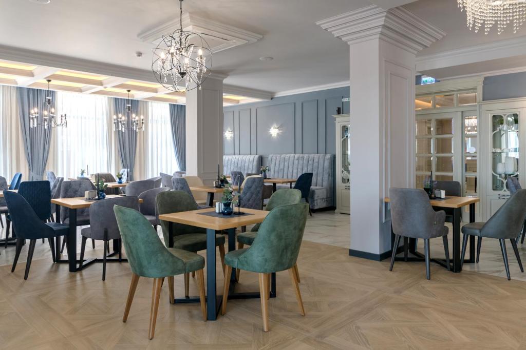 克兰内沃Aquamarine - Wellness & SPA Hotel的一间带桌椅和吊灯的餐厅
