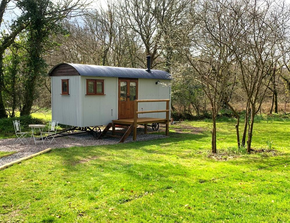 霍尔斯沃西Lilliput - Delightful 1-bedroom shepherd's hut的田野里带长凳的小棚子