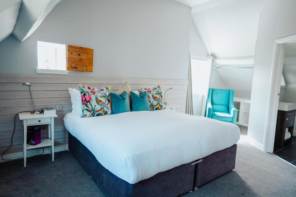 斯托桥The Fox Inn的一间卧室配有一张大床和一张蓝色椅子