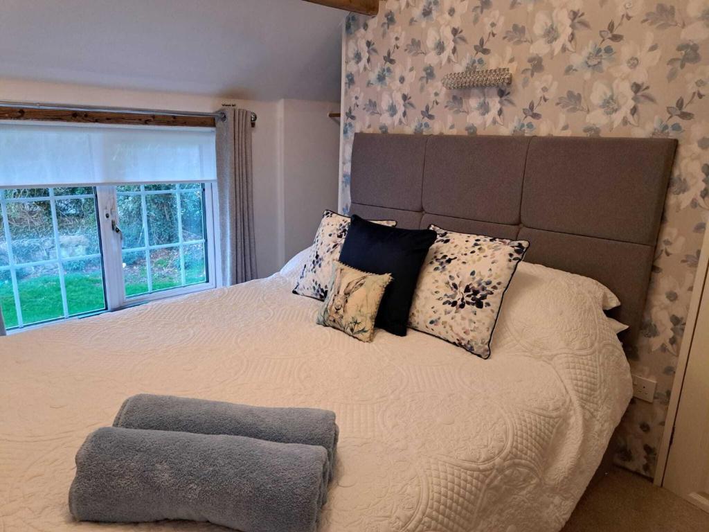 切斯特Saughall Mill Farm Cottage的一间卧室设有一张大床和大窗户