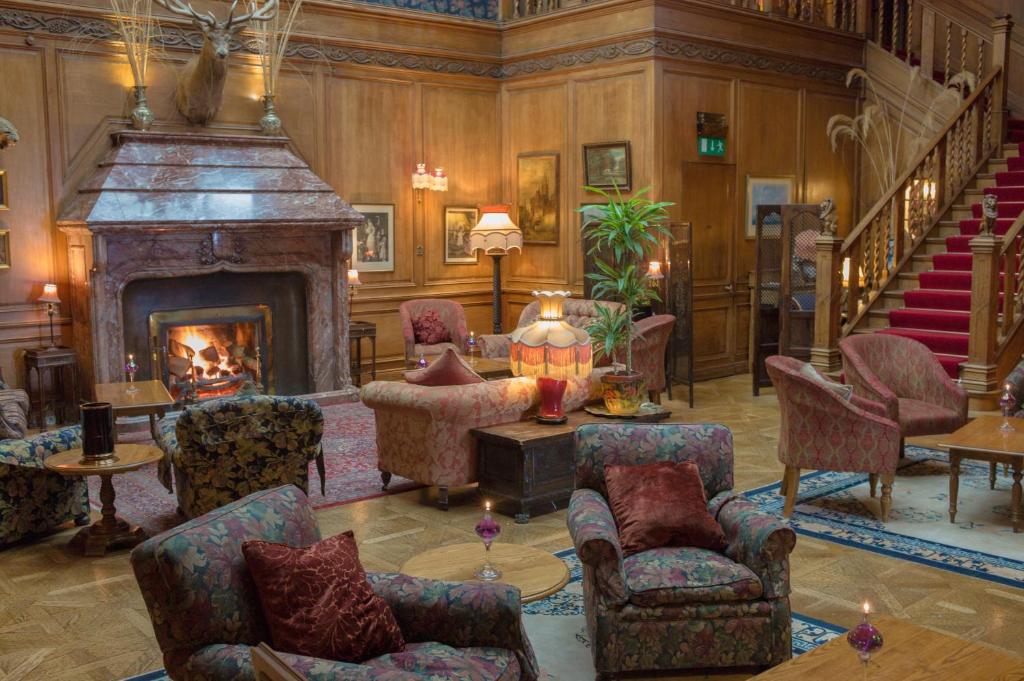 阿利士皇家天地酒店的一间带壁炉和楼梯的客厅