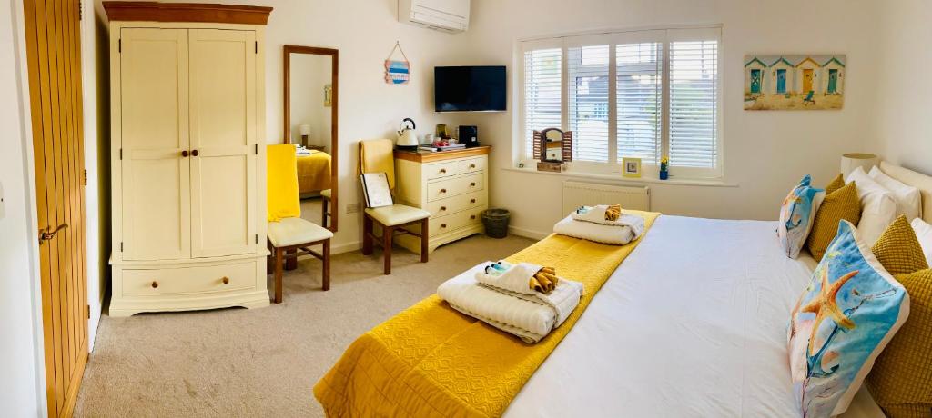 基督城Avon Beach Bed & Breakfast的一间卧室配有两张床、一个梳妆台和一张书桌。