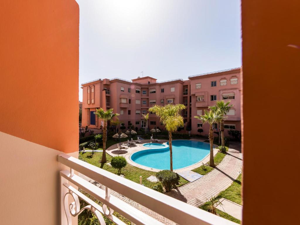 马拉喀什New Modern Apartment in Marrakech - Netflix - WiFi的从公寓的阳台可欣赏到游泳池的景色
