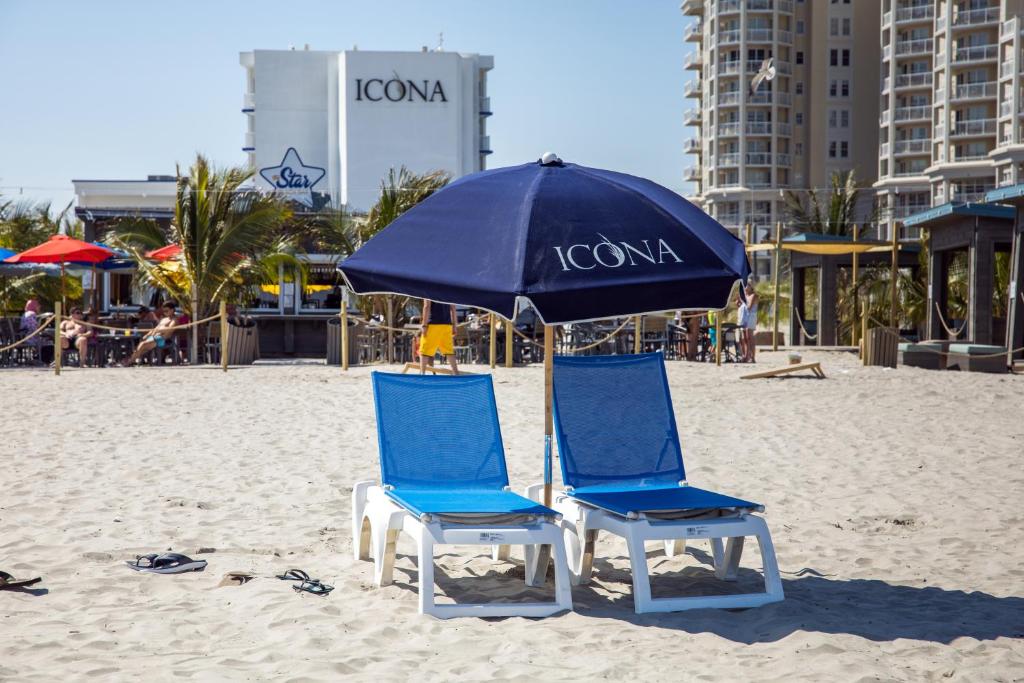 威尔伍德克拉斯特艾克纳钻石海滩酒店 的海滩上的两把椅子和一把遮阳伞