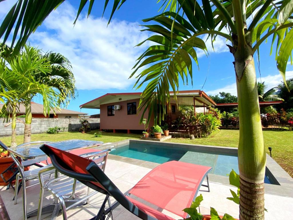 TaravaoTAHITI - Fare Matavai Hoe的一个带游泳池和棕榈树的别墅