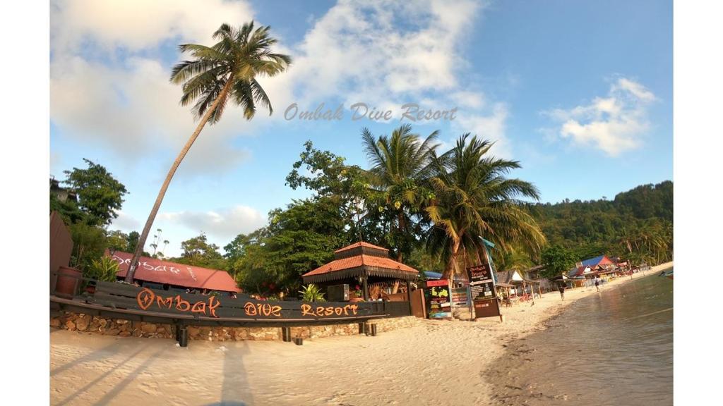 停泊岛Ombak Dive Resort Perhentian Island的一片拥有餐厅和棕榈树的海滩