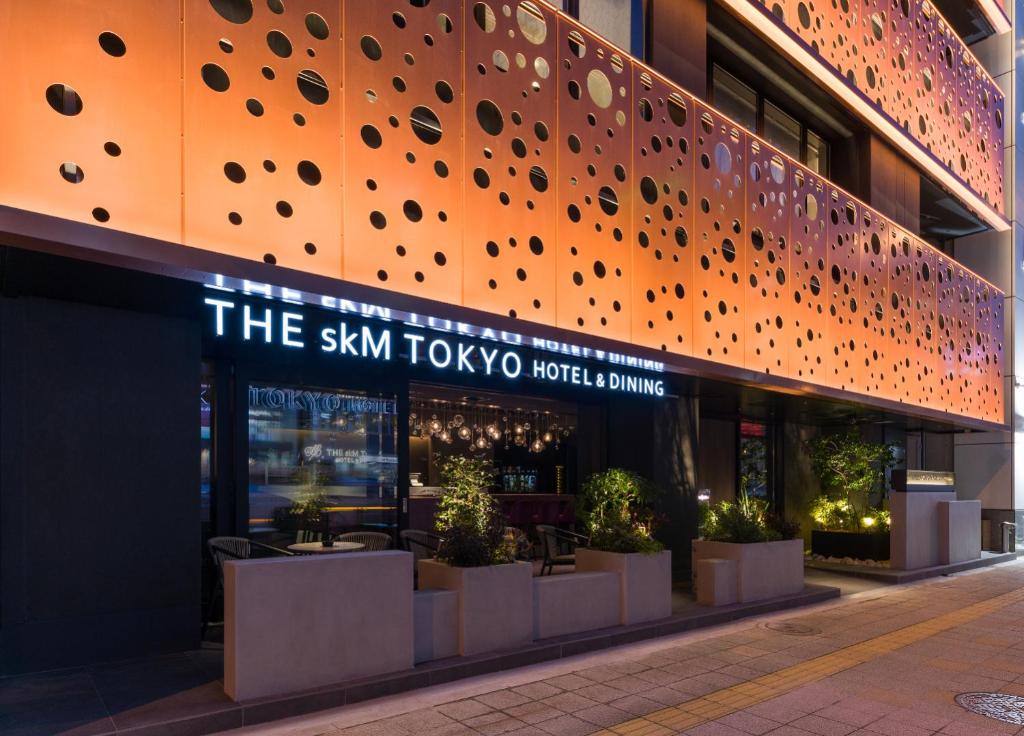 东京THE skM TOKYO HOTEL & DINING的一座建筑,上面有读天空的图标