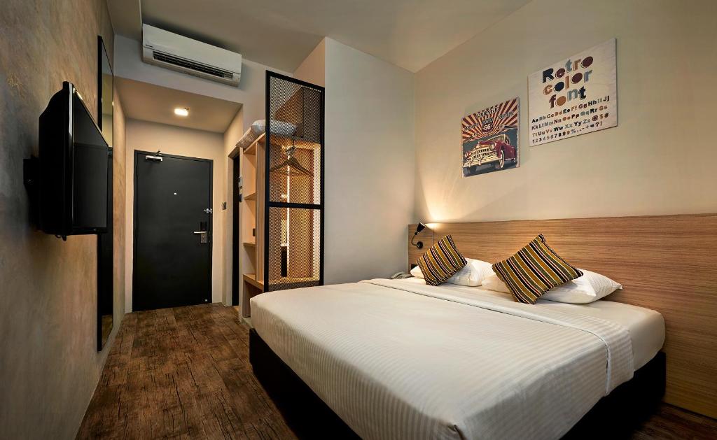 峇六拜槟城优酒店的卧室配有一张白色大床和电视。