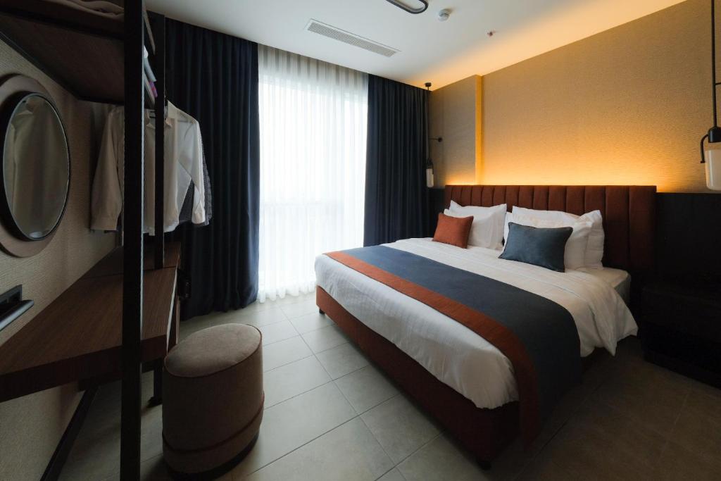 伊斯坦布尔The Kailyn Hotels&Suites Ataşehir的一间位于酒店客房内的带大床的卧室