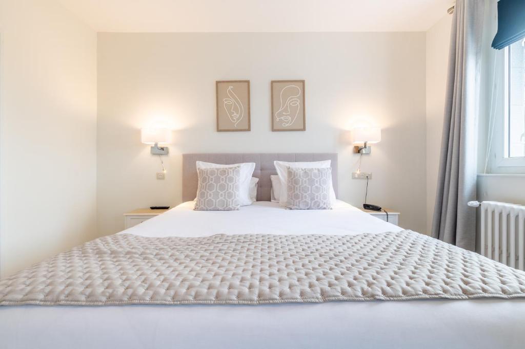 索姆河畔的圣瓦列里Hôtel Échappée en Baie - Parking privé gratuit dont forfaits bornes électriques réservable的卧室配有白色的床和2个枕头