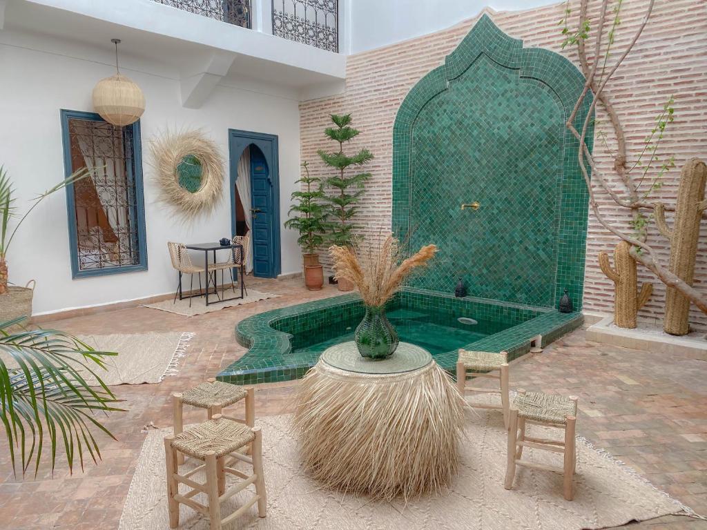 马拉喀什Riad Dar Marrakcha的庭院设有桌椅和浴缸。