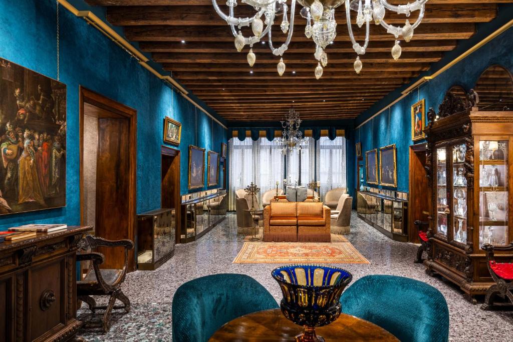 威尼斯帕拉佐普瑞里酒店的客厅拥有蓝色的墙壁和桌椅