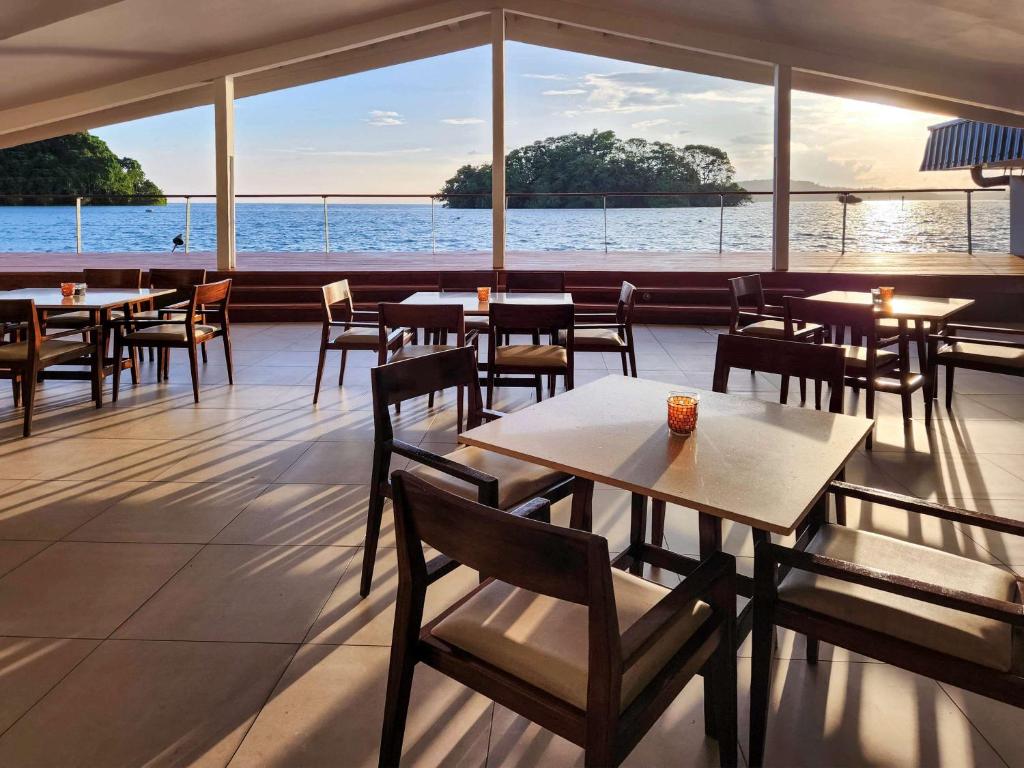 苏瓦诺富特苏瓦拉米湾酒店的一间带桌椅并享有水景的餐厅