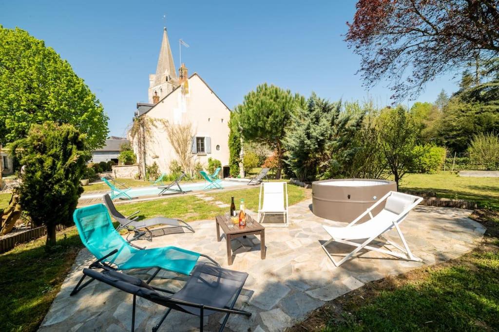 ThilouzeLe Clos du Tilleul Fabuleuse propriété 15 à 30 Pers Piscine au coeur d'un charmant village的庭院配有桌椅和浴缸。