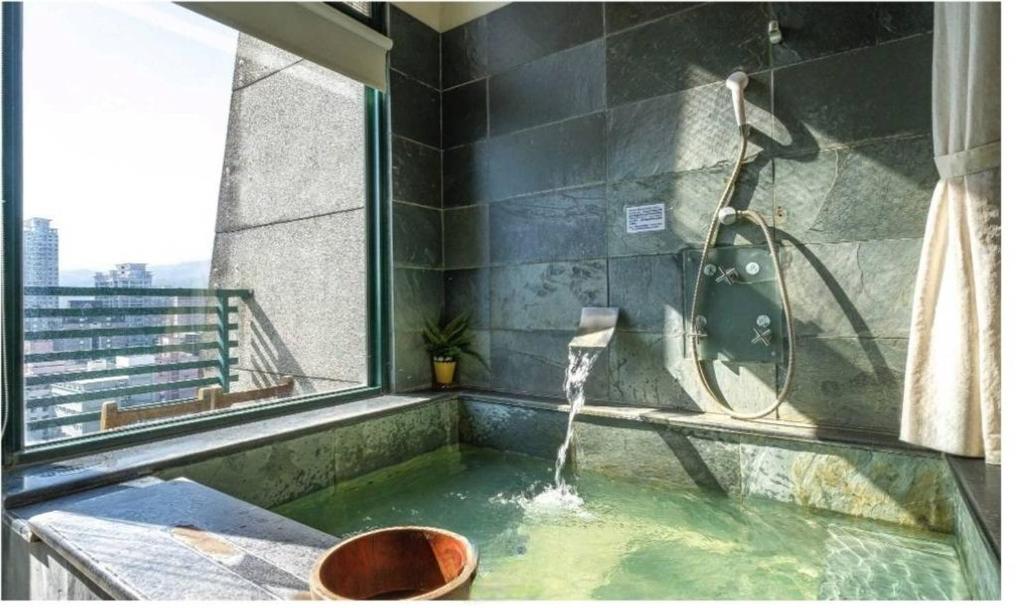 礁溪泉泉溫泉民宿的带浴缸和淋浴的浴室