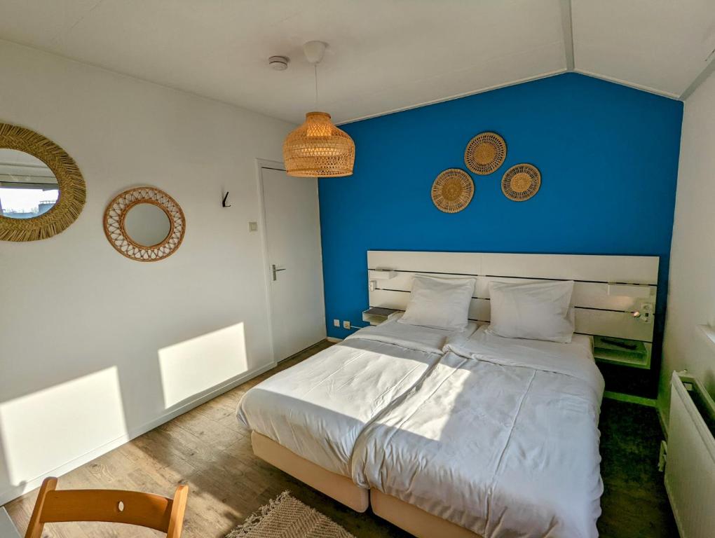 弗劳温普尔德Budget Hotel Vrouwenpolder的一间卧室设有一张蓝色墙壁的大床
