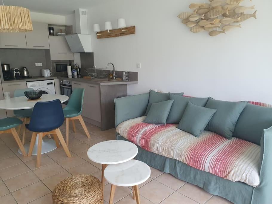 比斯卡罗斯Mignon appartement en résidence avec piscine的一间带蓝色沙发的客厅和一间厨房