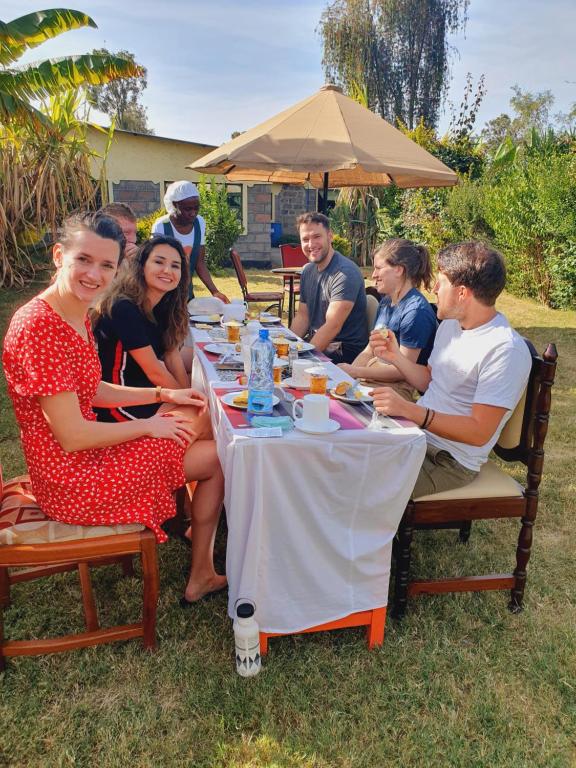 纳库鲁Homebase gardens的一群人坐在桌子旁