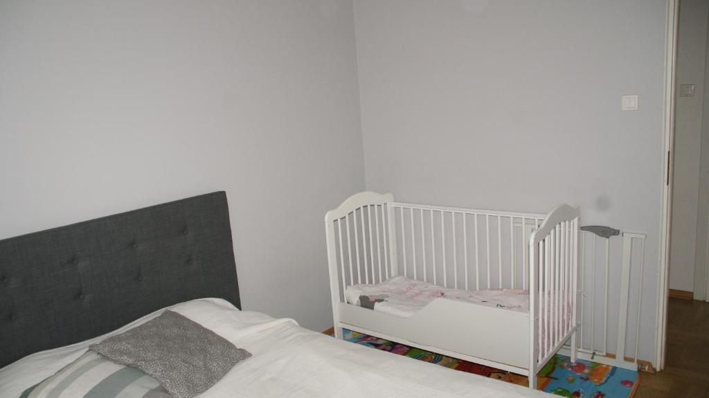 克拉科夫Apartament Alutka的卧室配有一张白色的婴儿床,卧室配有一张床
