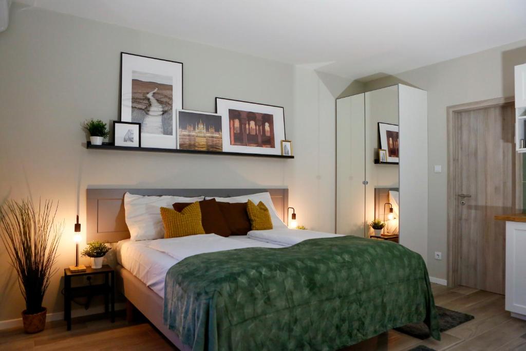 布达佩斯阿卡法假日公寓的一间卧室配有一张带绿毯的大床
