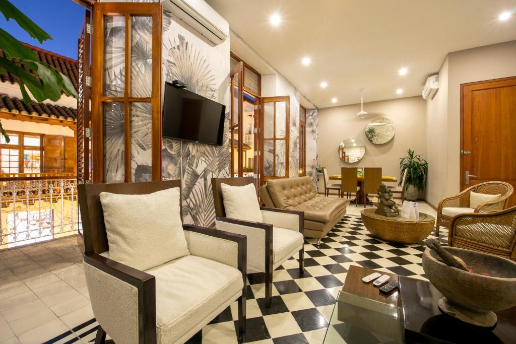 卡塔赫纳San Pedro Claver Luxury in the walled city的客厅配有椅子和墙上的电视