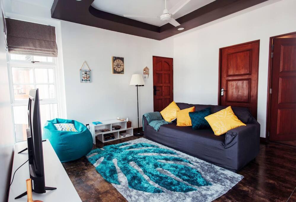 胡鲁马累Charming Beachfront 2BR Apartment in Hulhumale’的客厅配有蓝色的沙发和地毯。