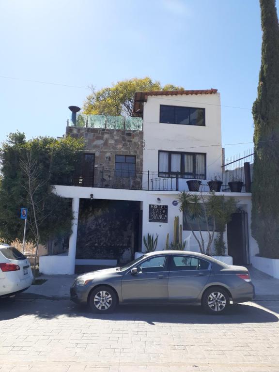 圣米格尔-德阿连德Casa Blanca San Miguel的停在房子前面的银色汽车