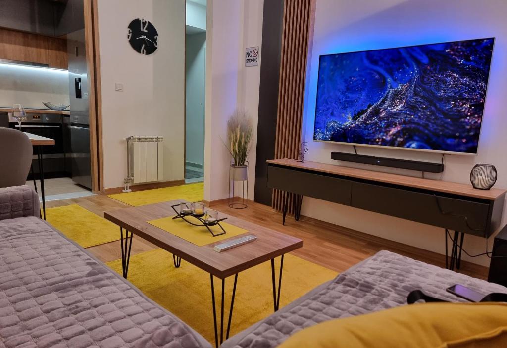 斯科普里Exclusive & Modern Apartment的带沙发和大屏幕电视的客厅