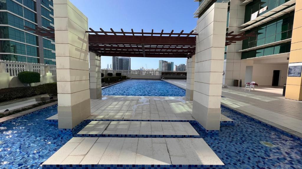 阿布扎比Prestigeo Guest House Abu Dhabi的一座建筑物中央的游泳池