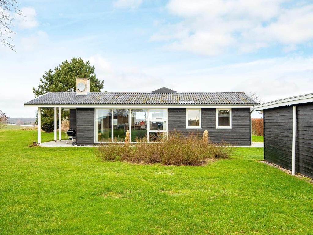 埃贝尔托夫特8 person holiday home in Ebeltoft的前面有绿色草坪的房子