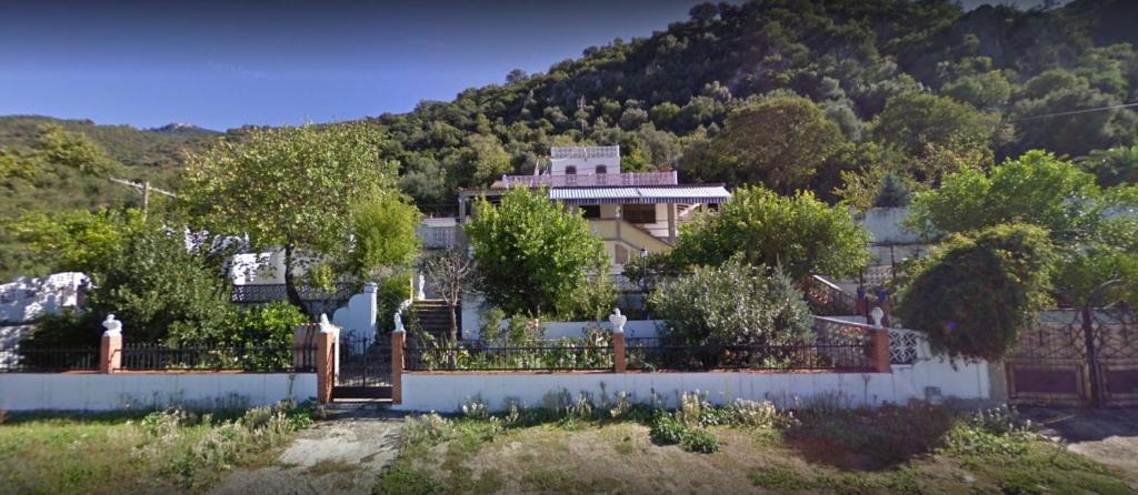 埃尔博斯克Alojamiento Rural Manantial de los Cañitos的山前有围栏的房子