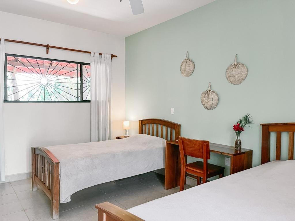 托拉Mar Adentro Sanctuary的一间卧室设有两张床、一张桌子和一个窗口。