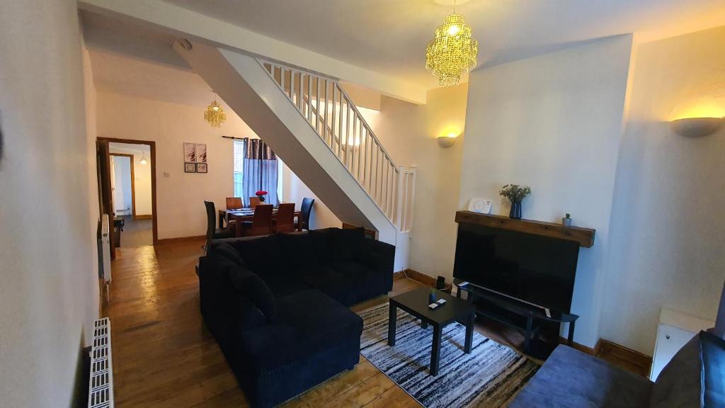 伯明翰Spacious 2 Bedroom Home in Birmingham的客厅设有黑色沙发和楼梯。