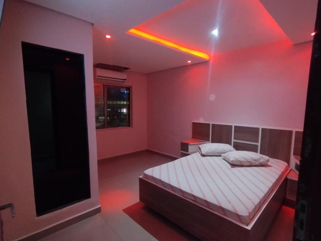 圣贝尔纳多-杜坎普Hotel Simba的一间卧室配有一张床和红灯