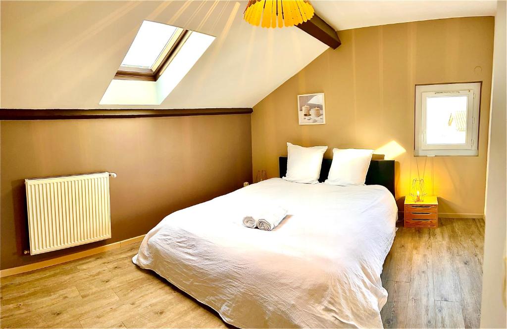 PéronnasLogement indépendant 1 à 2 chambres, idéal séjour Bourg en bresse的卧室配有一张白色的大床和天窗。