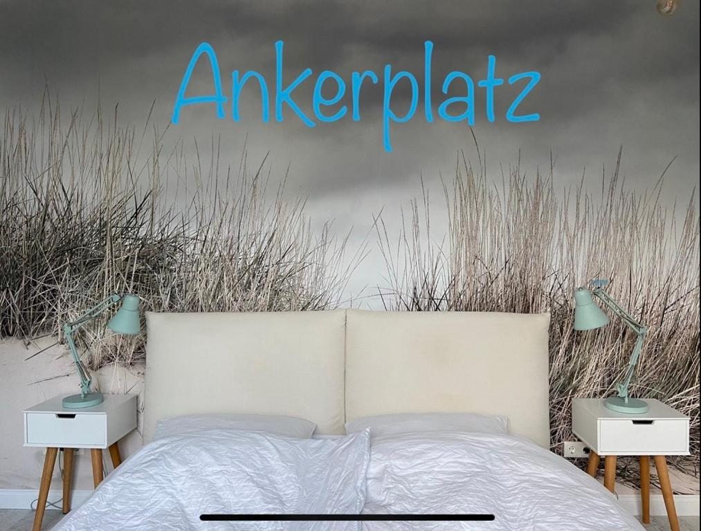 基尔Ankerplatz-1-Kiel的卧室配有白色的床、两个床头柜和标牌