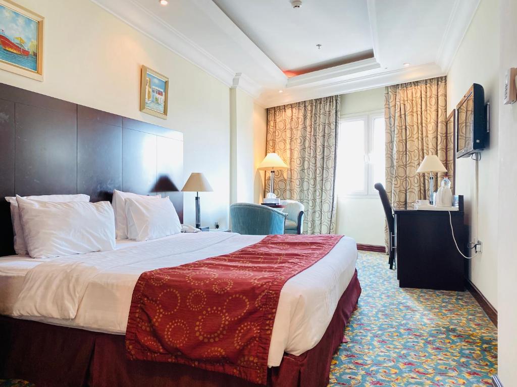多哈姆施立波酒店的酒店客房设有一张带红色毯子的大床
