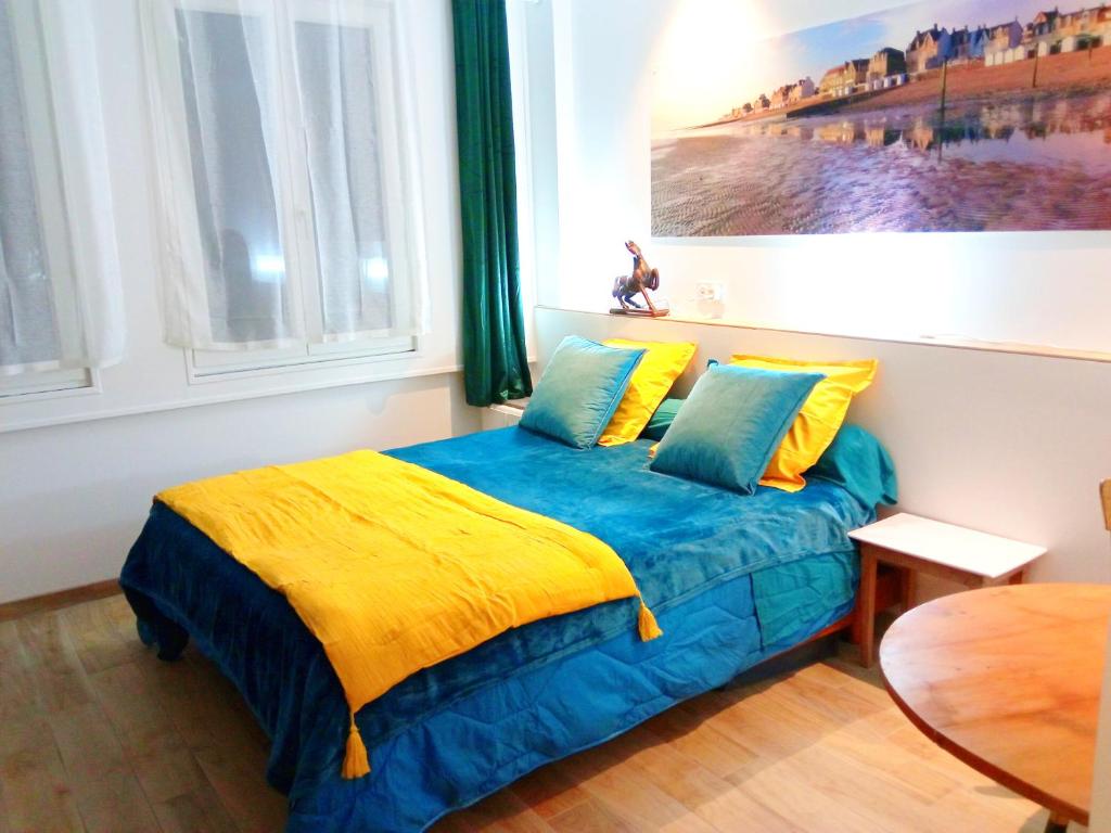 滨海圣奥班MYSaintAubin的一间卧室配有一张黄色和蓝色毯子的床