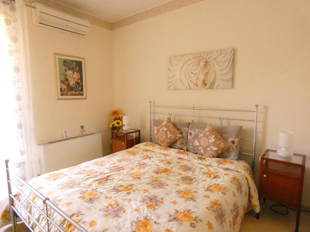 陶尔米纳Villa Magnolia B&B的一间卧室配有一张带花卉床罩的床