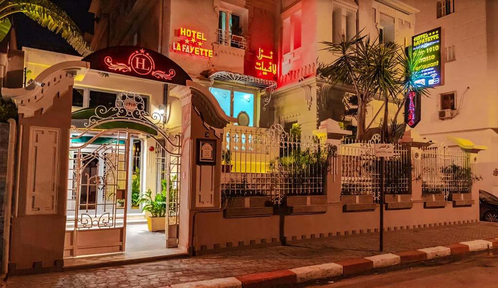 突尼斯HOTEL LAFAYETTE的夜间有 ⁇ 虹灯标志的建筑物入口