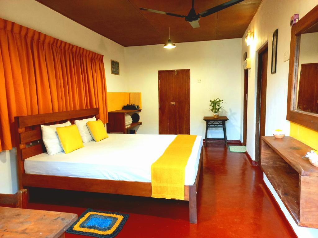 希克杜沃Coco Garden Villas 1的一间卧室配有一张带黄色枕头的大床