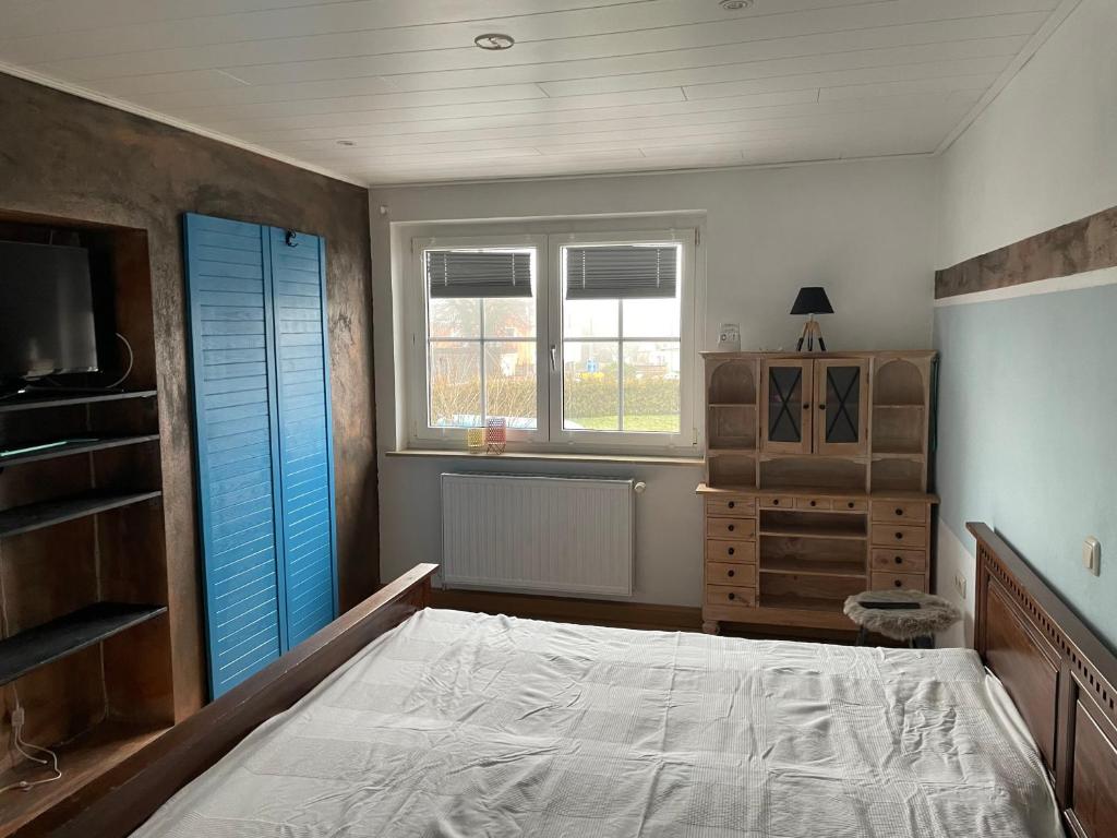 GattendorfFerienwohnung的一间卧室配有一张床、梳妆台和窗户。